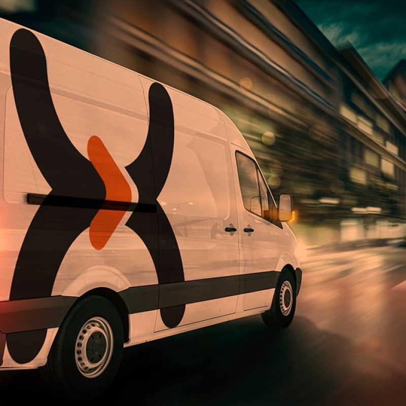 Last mile (1)-min Van branca com logotipo da Vex em alto movimento em uma rua